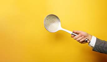 Eine Hand hält mit einer Schöpfkelle. Symbolisch für die Arbeit im Programm bei der Wyniger Gruppe