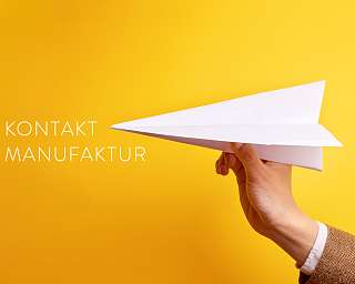 Eine Hand hält einen gefalteten Papierflieger. Symbolisch für Datenübertragung