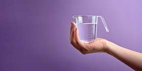 Eine Hand die einen mit Wasser gefüllten Messbecher hält. Symbolisch für die Fesstellung von Kompetenzen